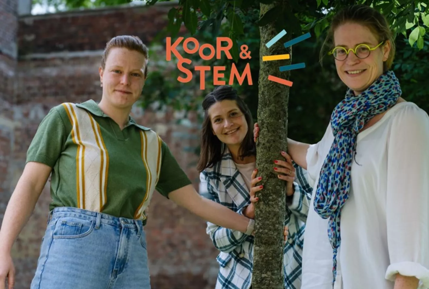 Drie medewerkers van Koor en Stem lachend op de foto